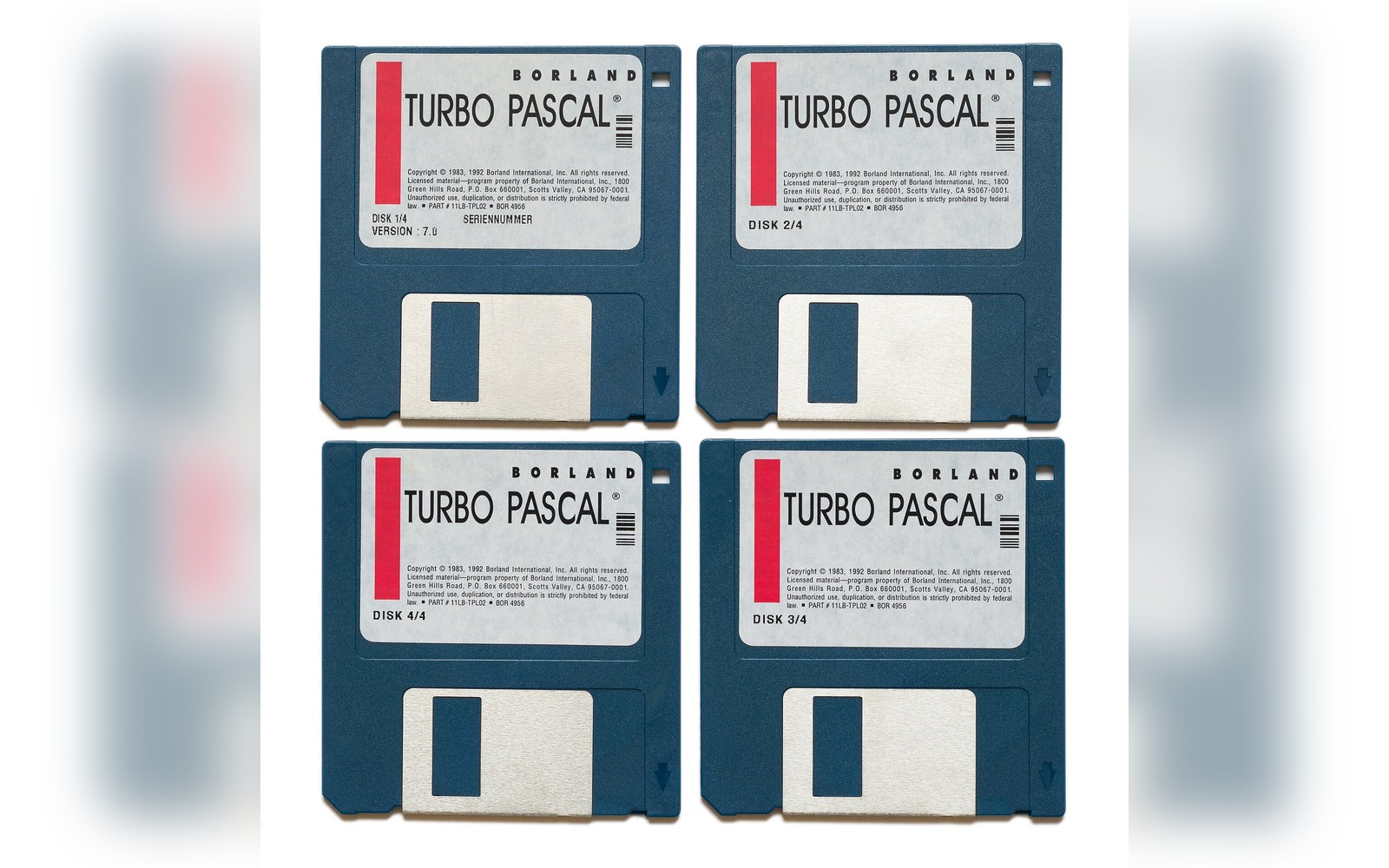 Four Borland Turbo Pascal floppy disks numbered 1 through 4 arranged in a grid
