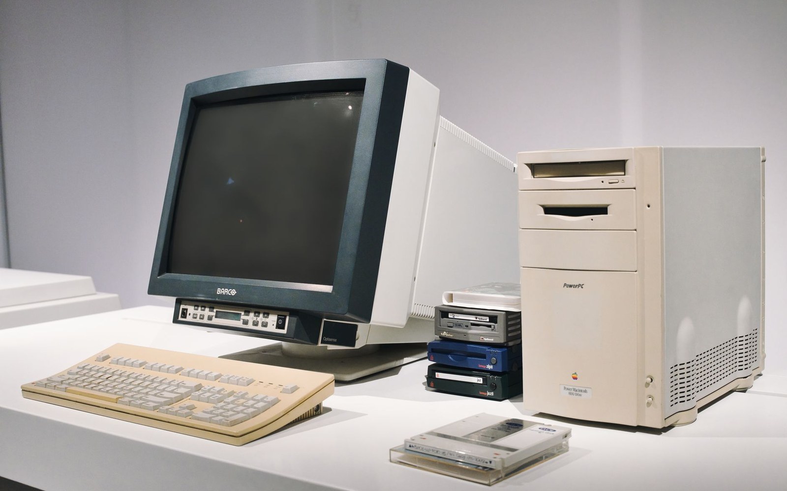Vintage Power Macintosh tower computer with CRT monitor, keyboard, and external drives on display