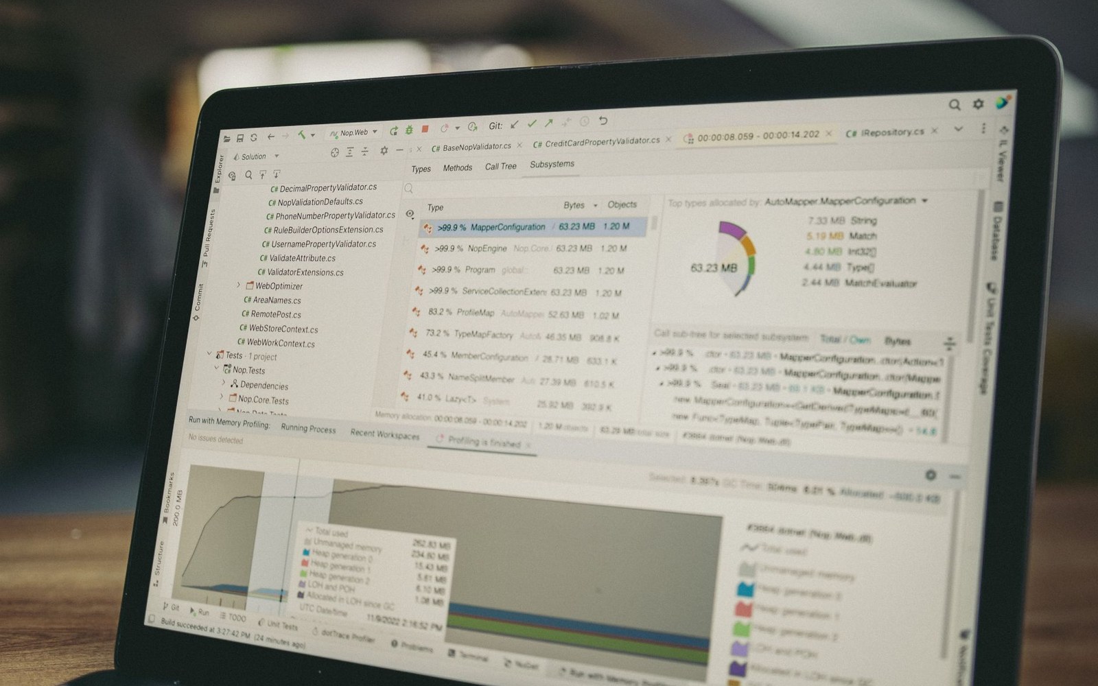 Laptop screen showing code profiling software with memory allocation charts and file lists